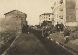 Pomiar długości bazy sieci triangulacyjnej w listopadzie 1918 r. Na zdjęciu są widoczne  drewniane łaty miernicze, leżące na drewnianych palach usytuowanych w dw&oacute;ch poziomach.